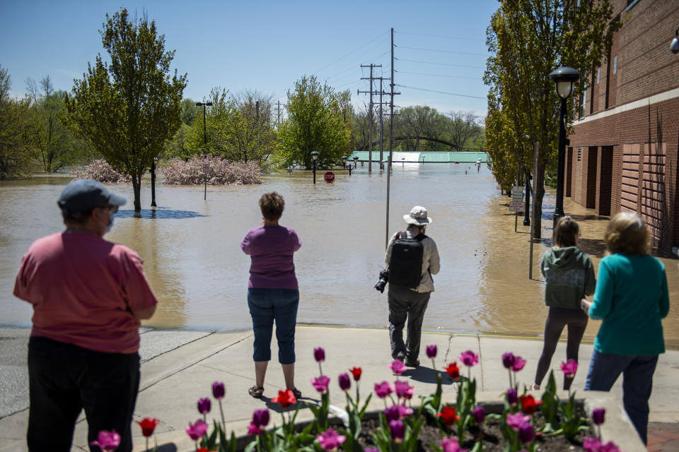People check out the flooding near the H Hotel in downtown Midland, Mich., on Wednesday, May 20, 2020. After the Edenville Dam failed and the Tittabawassee River flooded surrounding areas, many residents were urged to leave their homes. (Kaytie Boomer/The Bay City Times via AP)