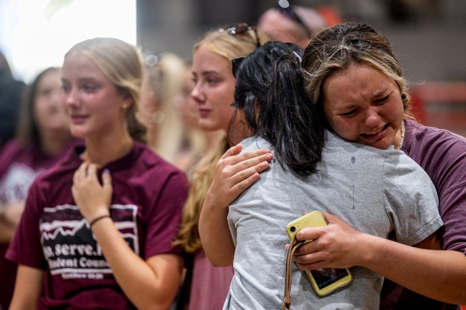 Community members embrace and mourn together at a vigil for the 21 victims in the mass shooting at Rob Elementary School