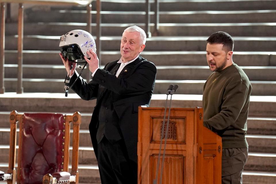 Speaker of the House of Commons, Sir Lindsay Hoyle, left, holds the helmet of one of the most successful Ukrainian pilots, inscribed with the words "We have freedom, give us wings to protect it", which was presented to him by Ukrainian President Volodymyr Zelenskyy as he addressed parliamentarians in Westminster Hall, London,, during his first visit to the UK since the Russian invasion of Ukraine, Wednesday Feb. 8, 2023.