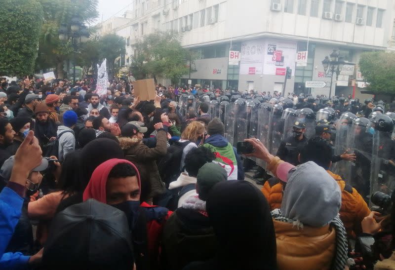 Police officers stand guard as demonstrators take part in an anti-government protest in Tunis