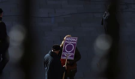 A man holds a placard in support of Spain's party "Podemos" (We Can) as he gathers, before the start of a rally called by Podemos, at Madrid's landmark Puerta del Sol January 31, 2015. REUTERS/Sergio Perez