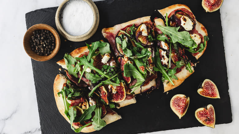 sliced flatbread on black board with seasoning