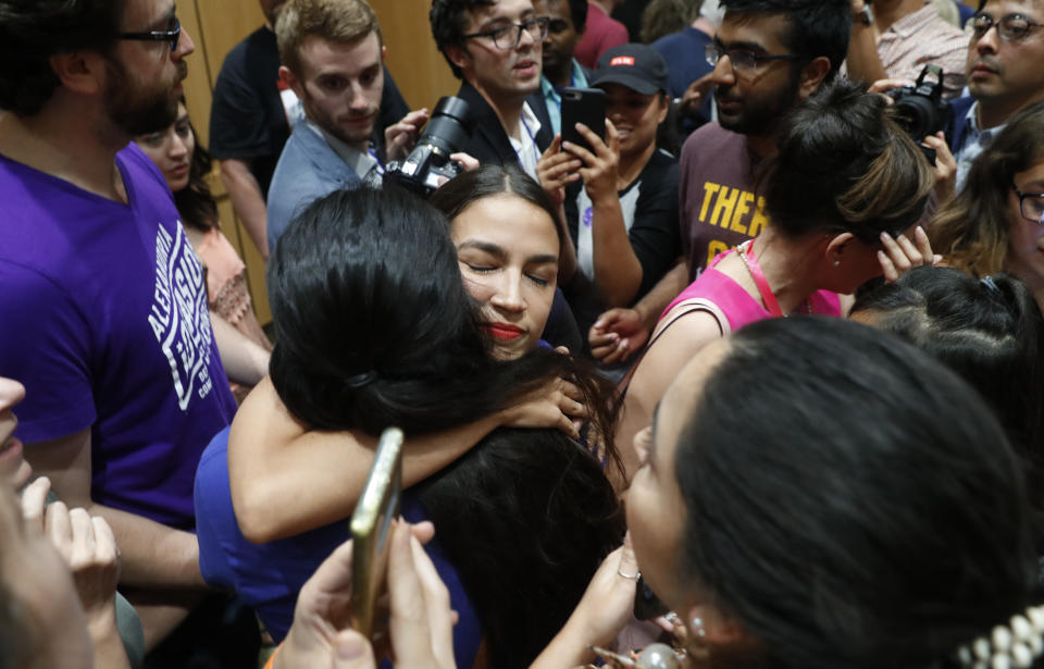 FILE - In this Saturday, July 28, 2018, file photo, Alexandria Ocasio-Cortez, a Democratic congressional candidate from New York, hugs a woman in the audience while she campaigns for Michigan Democratic gubernatorial candidate Abdul El-Sayed in Detroit. Ocasio-Cortez is trying to leverage the 17,000 votes that gave her a primary win in New York into a national movement. (AP Photo/Paul Sancya, File)