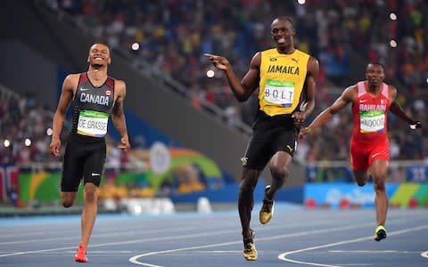 Jamaica's Usain Bolt (C) jokes with Canada's Andre De Grasse (L) after they crossed the finish line in the Men's 200m Semifinal during the athletics event at the Rio 2016 Olympic Games at the Olympic Stadium in Rio de Janeiro on August 17, 2016 - Credit: Getty Images