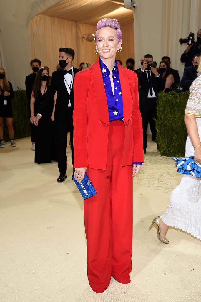 Megan Rapinoe in a Sergio Hudson suit, Giuseppe Zanotti platform boots and an Edie Parker clutch. - Credit: AP Images