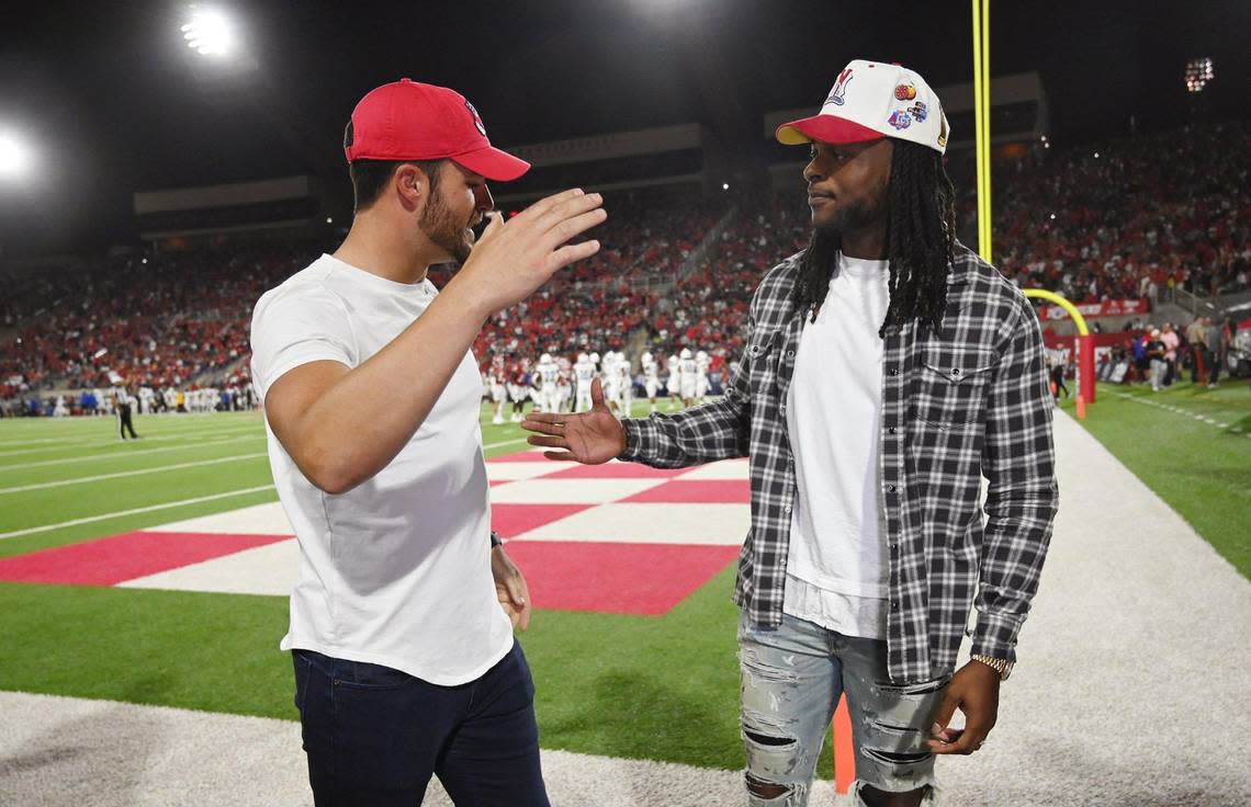 Derek Carr, left, extends his hand to Davonte Adams, right, Saturday, Oct. 15, 2022 in Fresno.