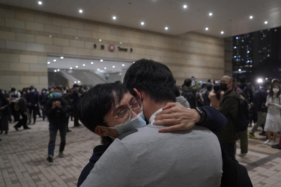 Friends of the 47 pro-democracy activists hug each other outside a court in Hong Kong, Thursday, March 4, 2021. A Hong Kong court on Thursday remanded all 47 pro-democracy activists charged under a Beijing-imposed national security law in custody, ending a four-day marathon court hearing. (AP Photo/Kin Cheung)