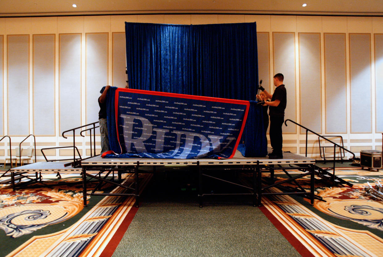 Trabajadores retiran la pancarta de fondo del candidato presidencial republicano Rudy Giuliani tras su discurso en el Portofino Bay Hotel en Universal Orlando en Orlando, Florida, el 29 de enero de 2008. (Chip Litherland/The New York Times)