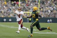 Washington Football Team's Taylor Heinicke throws with Green Bay Packers' Rashan Gary defending during the second half of an NFL football game Sunday, Oct. 24, 2021, in Green Bay, Wis. (AP Photo/Aaron Gash)