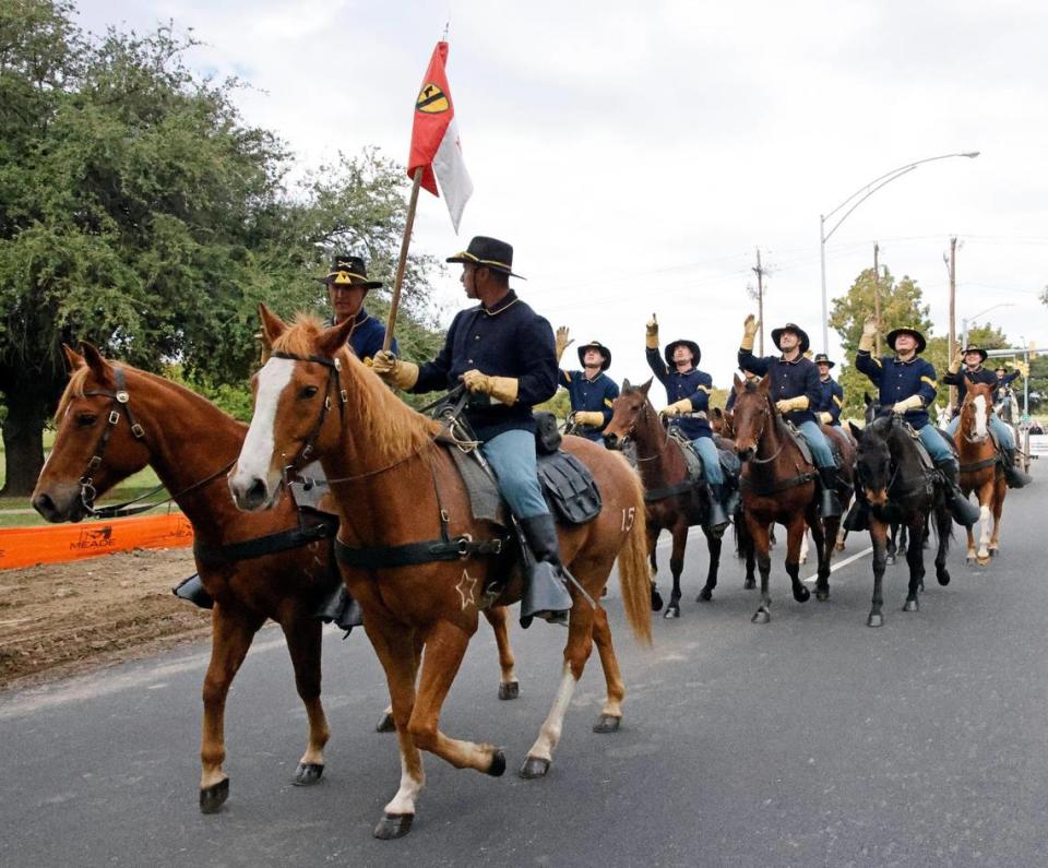 Members of the 1st Team Cavalry Division Horse Detachment from Fort Cavazos wave to parade spectators. 