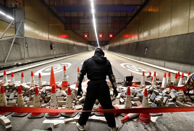 FILE PHOTO: An anti-government protester stands at a blocked outlet of the Cross Harbour Tunnel near the Polytechnic University in Hong Kong