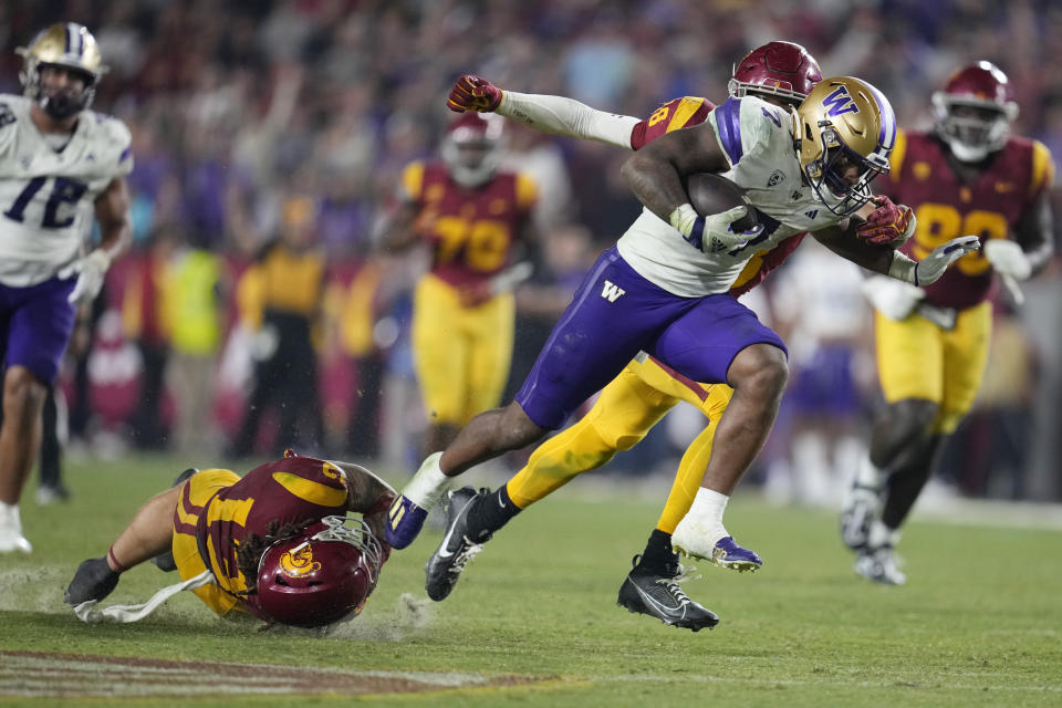 Washington running back Dillon Johnson (7) runs past Southern California linebacker Mason Cobb, bottom left, during the second half of an NCAA college football game Saturday, Nov. 4, 2023, in Los Angeles. (AP Photo/Marcio Jose Sanchez)