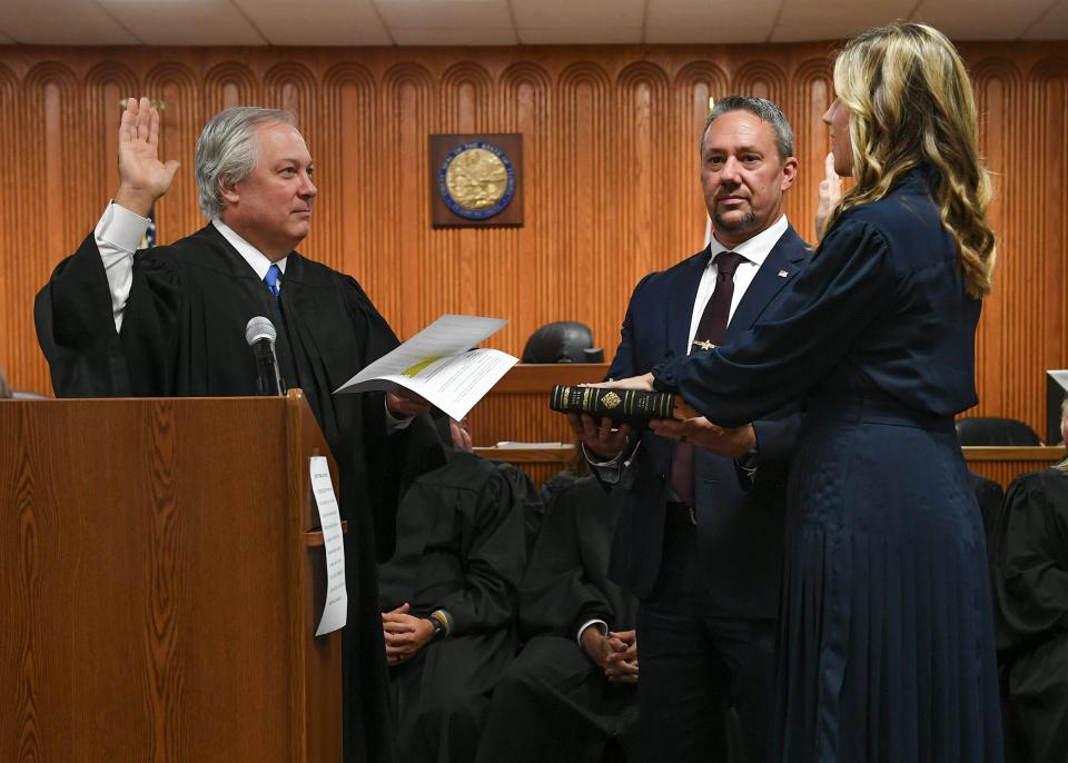 The Honorable Charles Schwab, Chief Justice of the 19th Judicial Circuit (left), swears in the newest Circuit Judge Anastasia Norman, with her husband St. Lucie County Sheriff’s Capt. Troy Norman at her side, during Judge Norman's investiture ceremony at the St. Lucie County Courthouse on Friday, Oct. 13, 2023, in Fort Pierce.