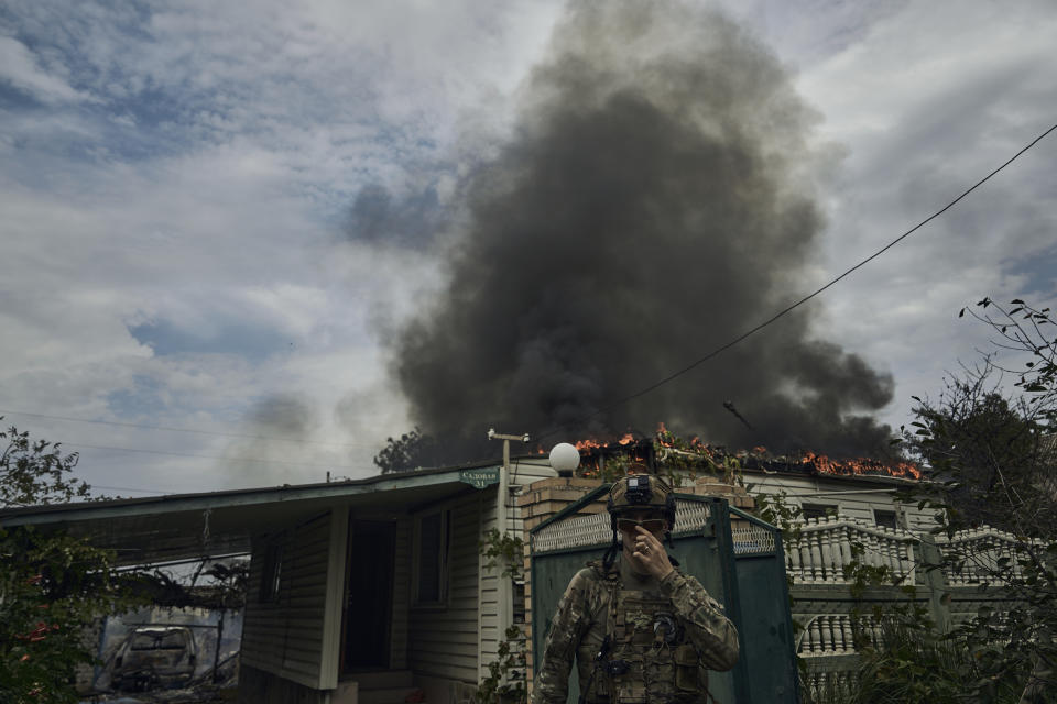 A Ukrainian soldier passes by a burning house after the Russian shelling close to the front line in Seversk, Donetsk region, Ukraine, Friday, Sept. 1, 2023. (AP Photo/Libkos)
