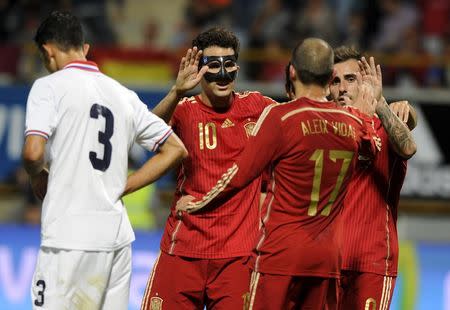 Spain's Cesc Fabregas celebrates a goal with teammates Alex Vidal and Francisco Alcacer (R) next to Costa Rica's Giancarlo Gonzalez (L) during their international friendly soccer match at the Reino de Leon stadium in Leon, northern Spain, June 11, 2015. REUTERS/Eloy Alonso