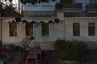 Pham Van Sang, a 50-year-old street food vendor who moved from the Mekong Delta, cleans a table set up alongside a mansion in Ho Chi Minh City, Vietnam, Monday, Jan. 22, 2024. He sells noodles in the city's industrial zone, a popular destination for many migrants from the Mekong Delta seeking a better life as he did. (AP Photo/Jae C. Hong)