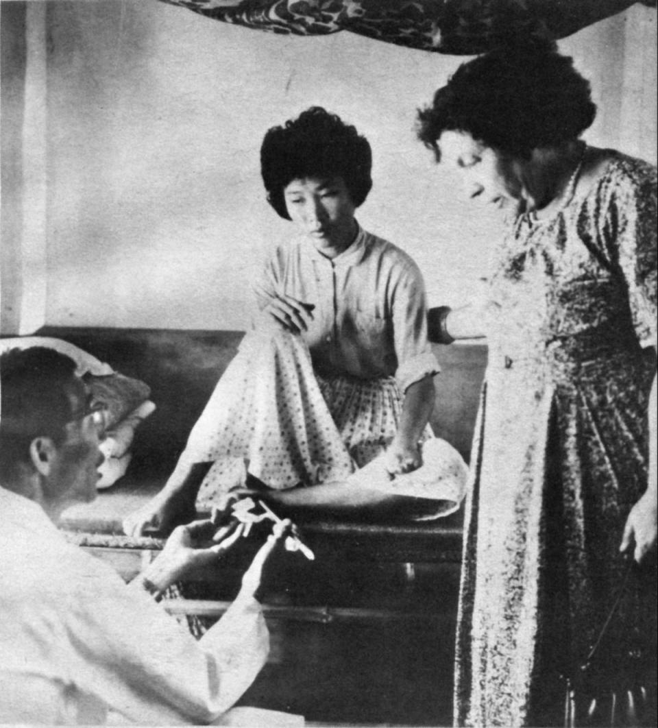 孫理蓮（右）探視烏腳病患者，王金河醫師（左）說明感染的情況。（基督教芥菜種會提供）