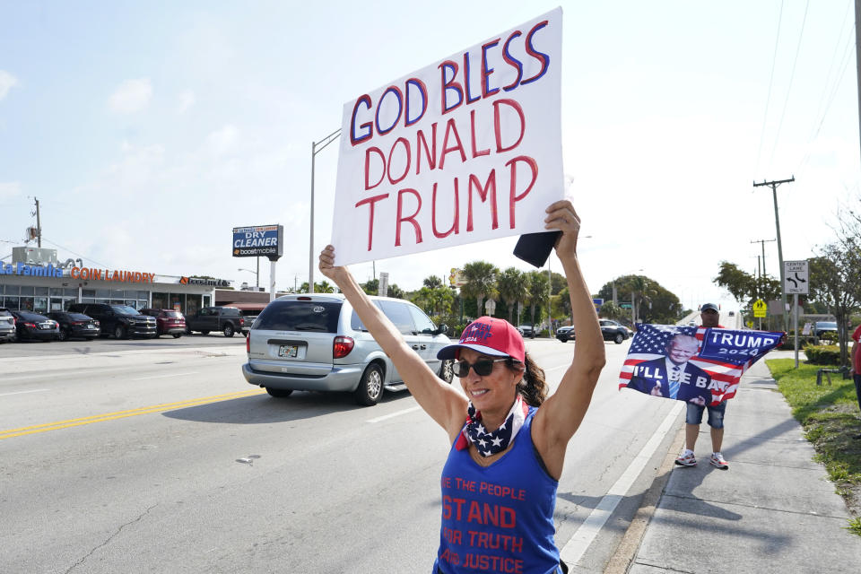 Janet Castro, a supporter of former President Donald Trump holds a sign during a rally, Monday, April 3, 2023, in West Palm Beach, Fla. (AP Photo/Wilfredo Lee)