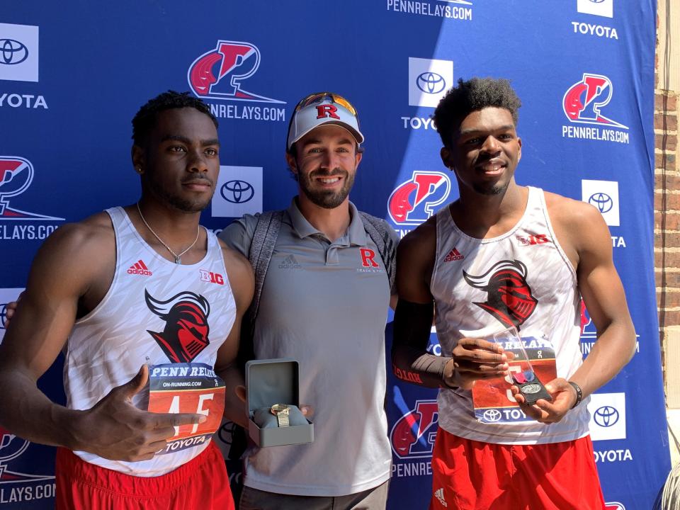 Rutgers A'nan Bridgett (left) holds his gold watch and teammate Sincere Robinson (right) holds his silver medal from the men's long jump at the Penn Relays. Between them is coach Corey Crawford