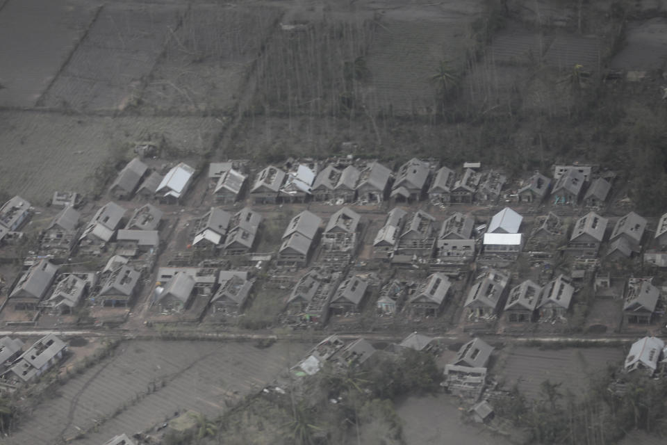 A village is covered in ash from the eruption of Mount Semeru in Lumajang district, East Java province, Indonesia, Monday, Dec. 6, 2021. The highest volcano on Java island spewed thick columns of ash into the sky in a sudden eruption Saturday triggered by heavy rains. Villages and nearby towns were blanketed and several hamlets buried under tons of mud from volcanic debris. (AP Photo/Trisnadi)