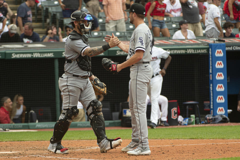 Chicago White Sox' catcher Yasmani Grandal, left, congratulates reliever Jimmy Lambert after a win over the Cleveland Guardians in a baseball game in Cleveland, Sunday, August 6, 2023. (AP Photo/Phil Long)