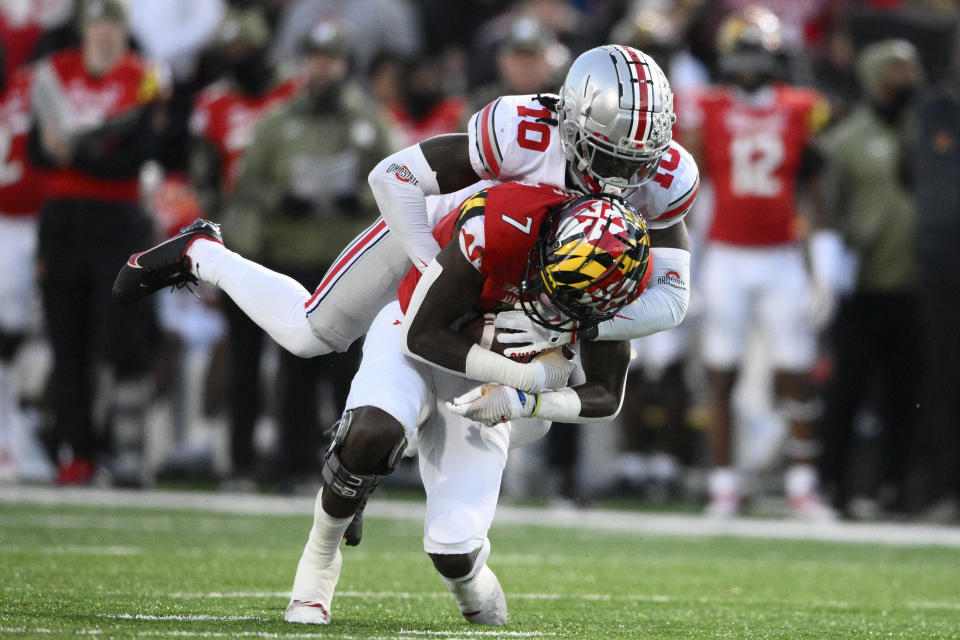 Ohio State cornerback Denzel Burke (10) tackles Maryland wide receiver Dontay Demus Jr. (7) during the first half of an NCAA college football game, Saturday, Nov. 19, 2022, in College Park, Md. (AP Photo/Nick Wass)