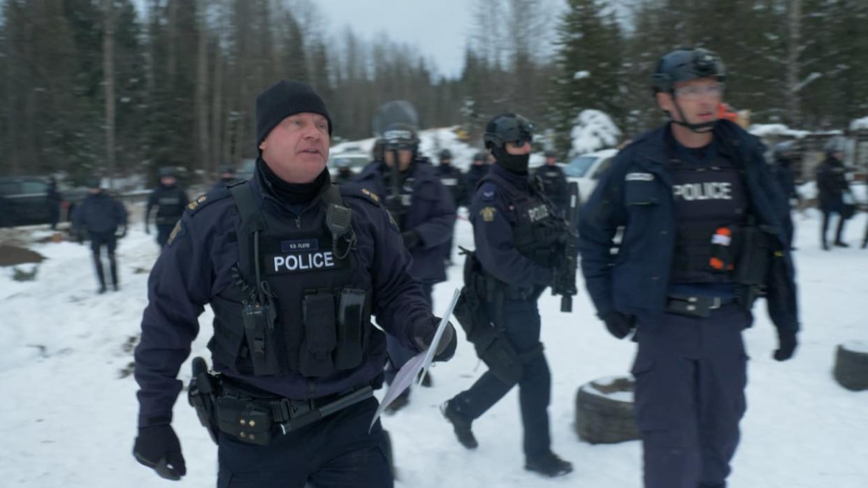 RCMP officers on the Morice River Forest Service Road on Friday, Nov. 19, 2021. (Submitted by Dan Loan - image credit)