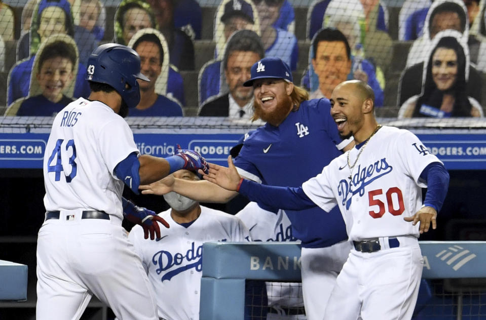 Edwin Rios #43 of the Los Angeles Dodgers celebrates with teammates Justin Turner and Mookie Betts #50 along with manager Dave Roberts after hitting a game tying solo home run against the Oakland Athletics in the eighth inning of a MLB baseball game at Dodger Stadium in Los Angeles on Wednesday, September 23, 2020. (Keith Birmingham/The Orange County Register via AP)