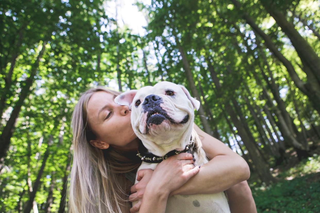 woman hugging dog outdoors