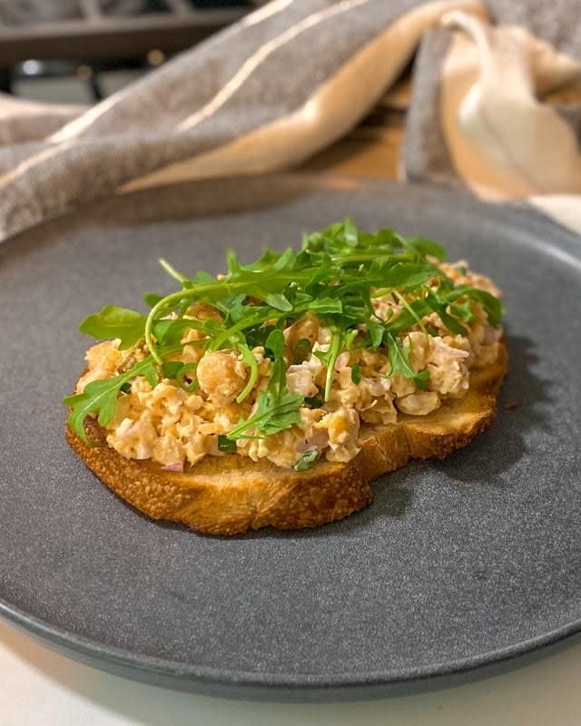 A piece of bread topped with chickpea salad.