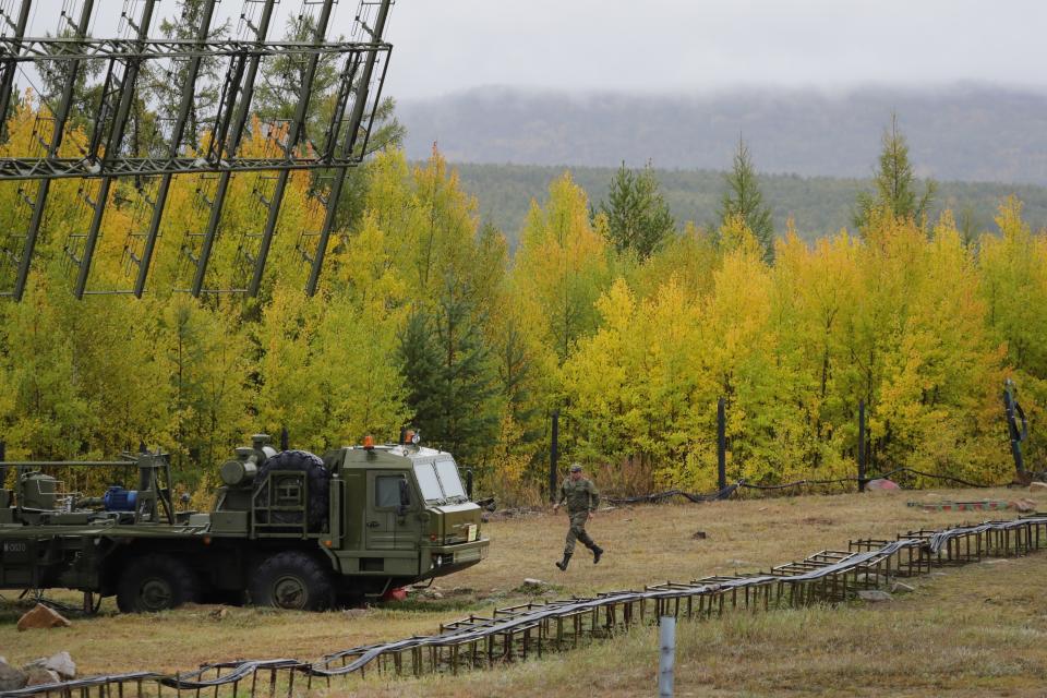 A Russian soldier runs towards a Nebo-M radar deployed by a forest, during a military exercises on training ground "Telemba", about 80 kilometers (50 miles ) north of the city of Chita during the military exercises Vostok 2018 in Eastern Siberia, Russia, Wednesday, Sept. 12, 2018. Hundreds of thousands Russian troops swept across Siberia on Tuesday in the nation's largest ever war games also joined by China — a powerful show of burgeoning military ties between Moscow and Beijing amid their tensions with the U.S. (AP Photo/Sergei Grits)