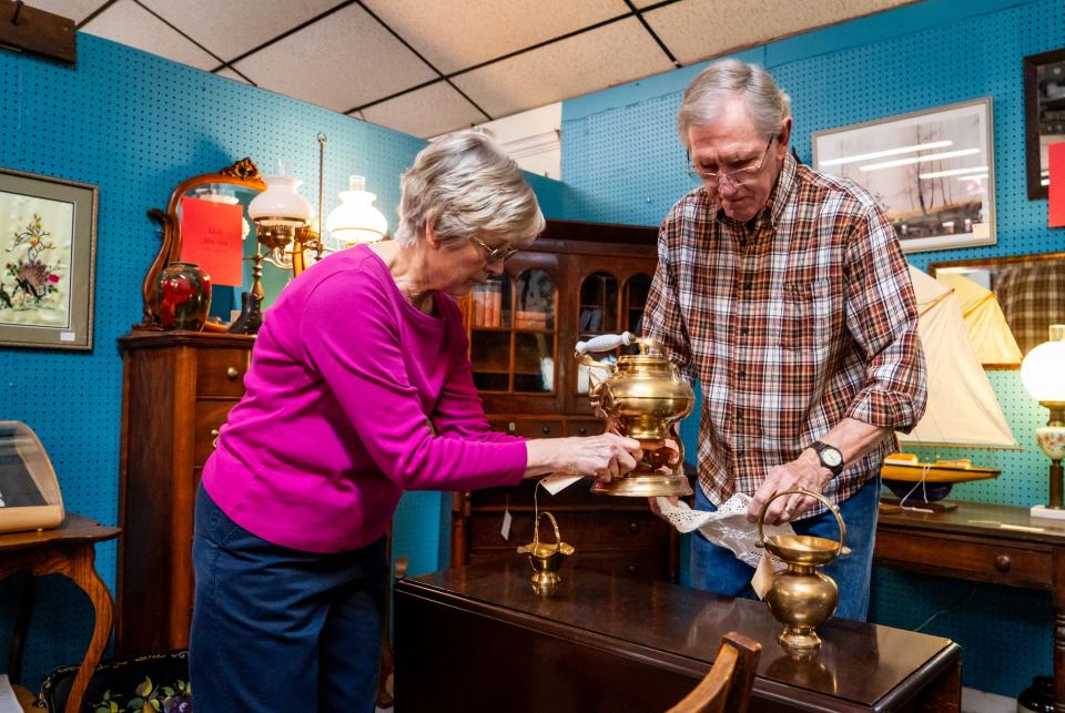 Carla and Bruce Fritz arrange items in their Austin Antique Mall booth. The Fritzes specialize in antique furniture, but they often sell decorations as well.