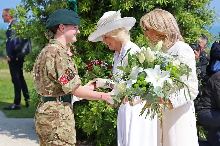 Brigitte Macron y la reina británica Camilla reciben ramos de flores durante el acto conmemorativo de la Real Legión Británica en el Memorial Británico de Normandía en Ver-sur-Mer, Normandía, en la costa norte de Francia, como parte de los actos de conmemoración del 80 aniversario del desembarco anfibio aliado (Desembarco del Día D) en Francia en 1944, el 6 de junio de 2024.