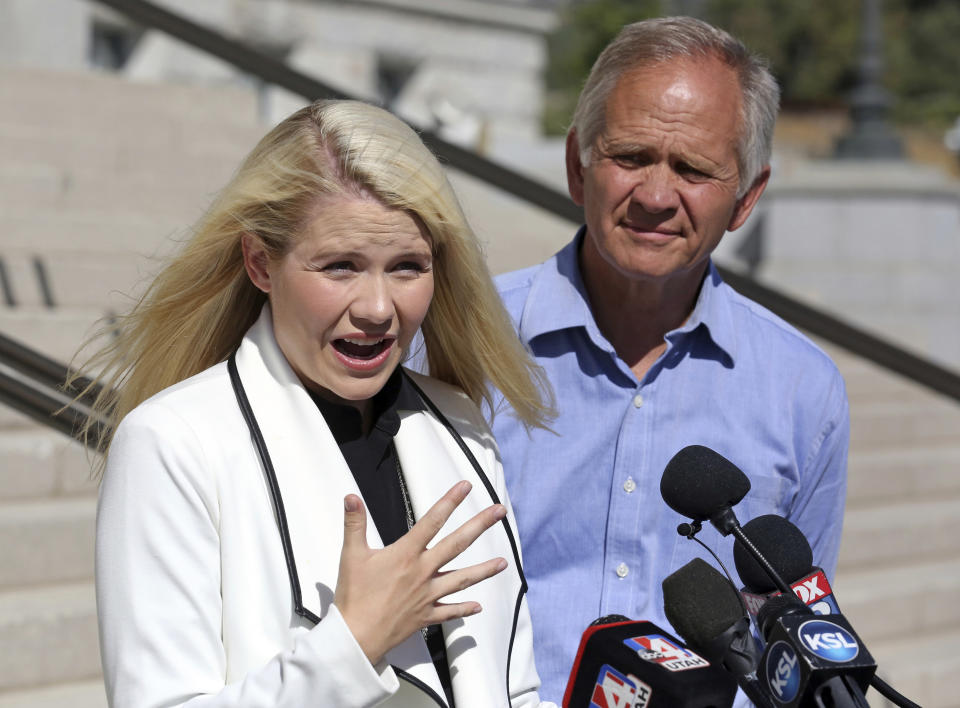 FILE - In this Sept. 13, 2018, file photo, Elizabeth Smart speaks during a news conference while her father Ed Smart looks on, in Salt Lake City. The father of Utah kidnapping survivor Elizabeth Smart has come out as gay, saying his decision brings challenges but also "huge relief." Ed Smart said in a letter explaining his decision shared Friday, August 16, 2019, with NBC's "Today" show that he no longer feels comfortable being a member of The Church of Jesus Christ of Latter-day Saints, which opposes same-sex relationships. (AP Photo/Rick Bowmer, File)