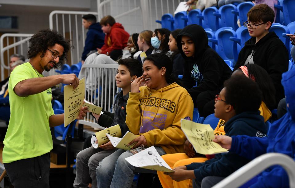 With their "Math Madness Day' activity books in hand, students from the Tatnuck Magnet Elementary School collect as many autographs as they can, including those from senior Mason Broyles of Millbury.