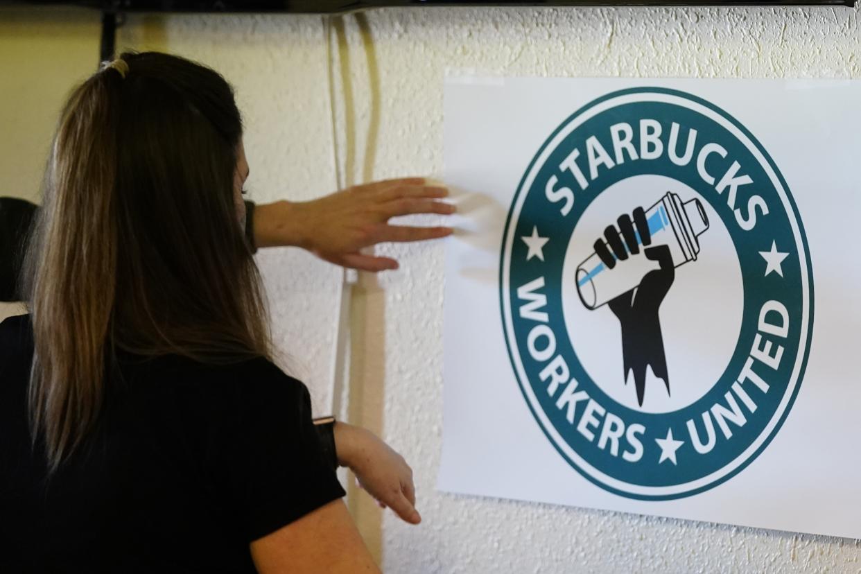 FILE - Michelle Eisen, a barista at the Buffalo, N.Y., Elmwood Starbucks location, helps out the local Starbucks Workers United, employees of a local Starbucks, as they gather at a local union hall to cast votes to unionize or not, on Feb. 16, 2022, in Mesa, Ariz. Federal labor officials filed a sweeping complaint Friday, May 6, 2022 accusing Starbucks of unfair labor practices at its stores in Buffalo, New York, including retaliation against pro-union employees.(AP Photo/Ross D. Franklin, File)