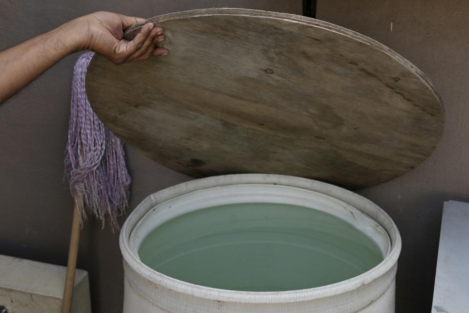 Aurelio Hernández, a taxi driver, lifts the lid of a bucket his home in Tijuana, Mexico, where many residents rely on water delivered by tanker trucks, on Friday, May 12, 2023. Among the last cities downstream to receive water from the shrinking Colorado River, Tijuana is staring down a water crisis. "It is the biggest problem we have," Hernandez said. (AP Photo/Carlos A. Moreno)