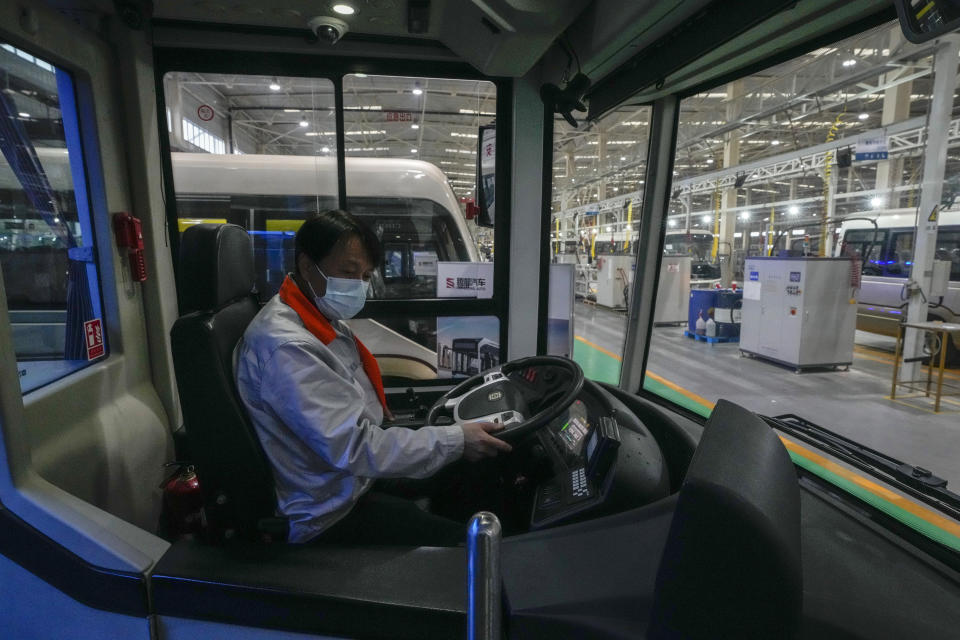 A worker checks on an assembled minibus at a Tenglong Automobile Co. manufacturing factory during a media-organized tour in Xiangyang in central China's Hubei Province on May 10, 2023. China's manufacturing and consumer spending are weakening after a strong start to 2023 after anti-virus controls ended. (AP Photo/Andy Wong)