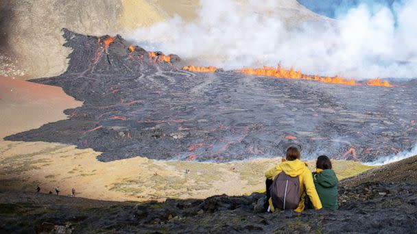 PHOTO: People look at the lava flowing at the scene of the newly erupted volcano at Grindavik, Iceland on Aug. 3, 2022. (Jeremie Richard/AFP via Getty Images)