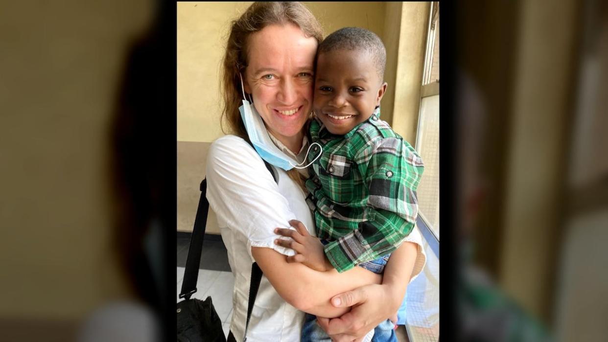 Charlene Berkvens holds her son in Lagos, Nigeria, in 2021, when she legally adopted him. She says she's heartbroken that after two years, they remain separated amid a lack of details from Immigration, Refugees and Citizenship on when her son will be able to come to Canada. (Submitted by Charlene Berkvens - image credit)