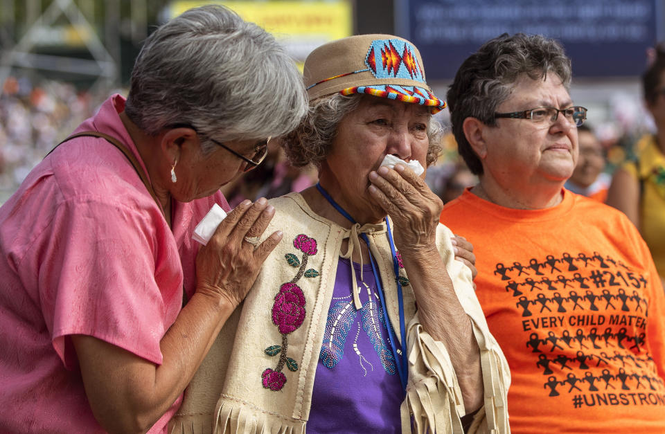 Nancy Saddleman, center, 82, cries as Pope Francis give mass in Edmonton, during his papal visit across Canada on Tuesday July 26, 2022. (Jason Franson/The Canadian Press via AP)