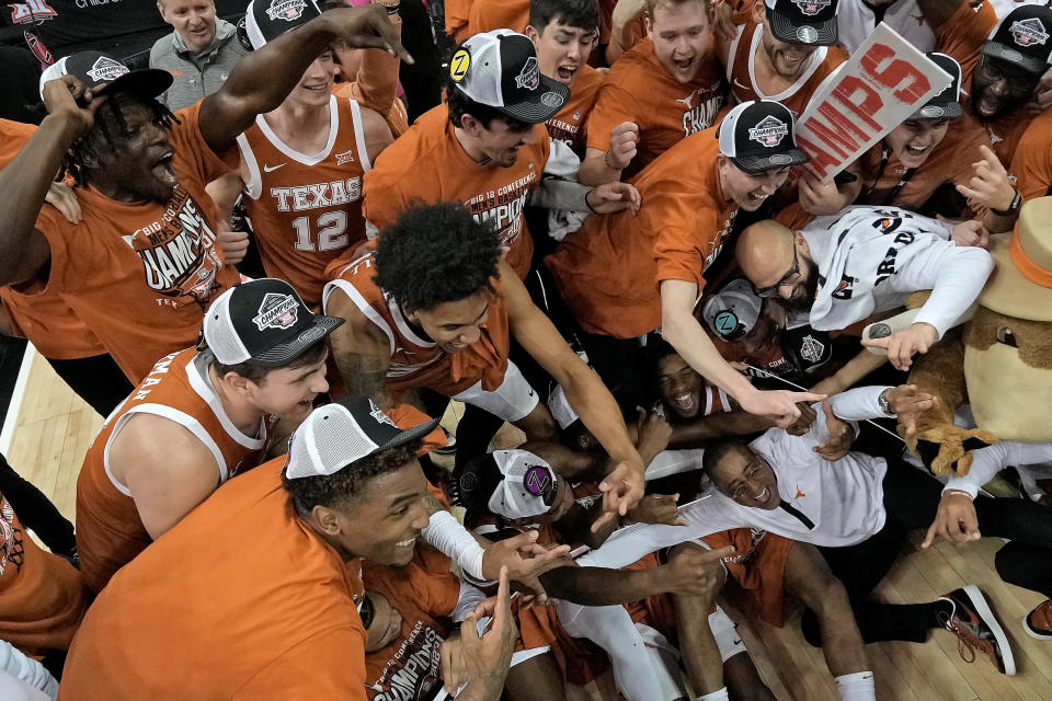 Interim Texas head coach Rodney Terry, bottom right, celebrates with his team after Texas won the Big 12 Conference tournament championship NCAA college basketball game against Kansas Saturday, March 11, 2023, in Kansas City, Mo. Texas won 75-56. (AP Photo/Charlie Riedel)