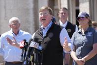 Mississippi Gov. Tate Reeves speaks to reporters, Sunday, March 26, 2023 in Rolling Fork, Miss., about the Friday night tornado that hit Rolling Folk, Miss., and other areas. Deanne Criswell, right, Administrator for the Federal Emergency Management Agency, and U.S. Sen. Roger Wicker, R-Miss., left, were among the federal officials that joined local officials in touring one of the neighborhoods hit by the tornado. (AP Photo/Rogelio V. Solis)