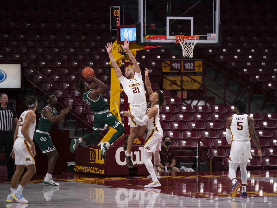 Minnesota's Jarvis Omersa (21) and Brandon Johnson defend against Green Bay's P.J. Pipes during an NCAA college basketball game Wednesday, Nov. 25, 2020, in Minneapolis. (Jeff Wheeler/Star Tribune via AP)