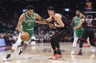 CORRECTS TO CELTICS' JAYSON TATUM NOT AL HORFORD AND TO RAPTORS' YUTA WATANABE NOT PRECIOUS ACHIUWA - Boston Celtics' Jayson Tatum, left, drives past Toronto Raptors' Yuta Watanabe during first-half NBA basketball game action in Toronto, Sunday, Nov. 28, 2021. (Chris Young/The Canadian Press via AP)