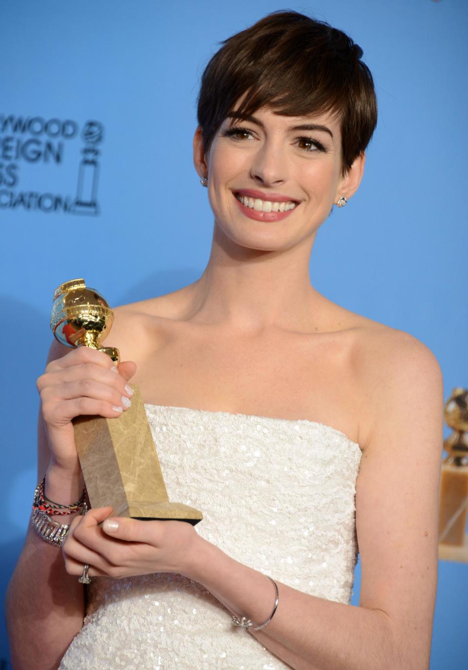 FILE - In this Jan. 13, 2013 file photo, Anne Hathaway poses with the award for best performance by an actress in a supporting role in a motion picture in "Les Miserables" backstage at the 70th Annual Golden Globe Awards at the Beverly Hilton Hotel, in Beverly Hills, Calif. Actors and actresses compete separately at awards shows, a tradition some in the industry consider vital for women but others question. (Photo by Jordan Strauss/Invision/AP, File)