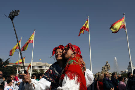 Women in traditional attire take a selfie during the annual sheep parade through Madrid, Spain, October 21, 2018. REUTERS/Susana Vera