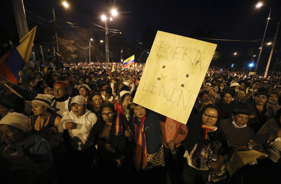 Indigenous protesters march through Quito, Ecuador, Thursday, Oct. 10, 2019, one with the Spanish message: "Get out Lenin," referring to the president. Big jumps in fuel prices after the government ended subsidies last week plunged Ecuador into upheaval, triggering protests, looting, vandalism, clashes with security forces, the blocking of highways and the suspension of parts of its vital oil industry. (AP Photo/Fernando Vergara)