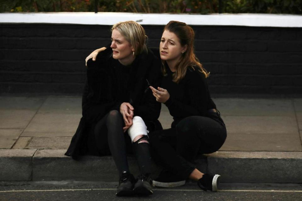 An injured woman reacts outside Parsons Green tube station. (Reuters)