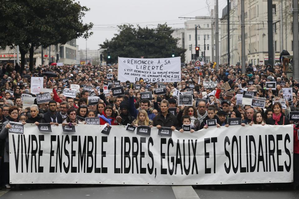 Several thousand people walk behind a banner which reads, Live Together Free, Equal, and United" as they march to pay tribute to the victims following a shooting Wednesday by gunmen at the office of the offices of the satirical weekly newspaper Charlie Hebdo during a demonstration in Nantes January 10, 2015. French police searched for a female accomplice to militant Islamists behind deadly attacks on the satirical Charlie Hebdo weekly newspaper and a kosher supermarket and maintained a top-level anti-terrorist alert ahead of a Paris gathering with European leaders and demonstration set for Sunday. In the worst assault on France's homeland security for decades, 17 victims lost their lives in three days of violence that began with an attack on the Charlie Hebdo weekly on Wednesday and ended with Friday's dual hostage-taking at a print works outside Paris and kosher supermarket in the city. The banner reads : live together, free, equal with solidarity. REUTERS/Stephane Mahe (FRANCE - Tags: CRIME LAW POLITICS SOCIETY CIVIL UNREST)